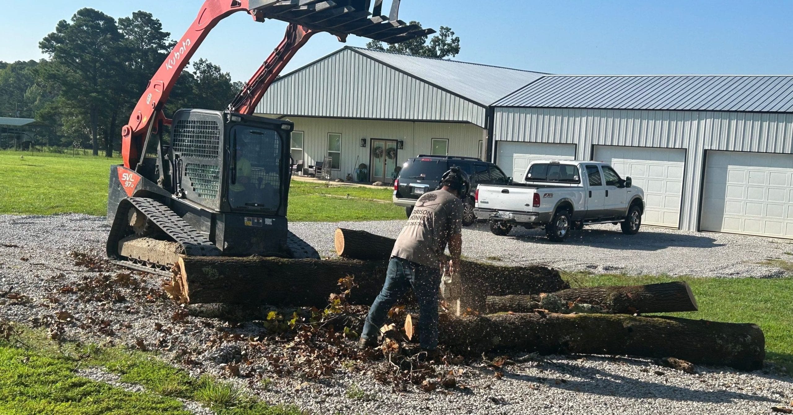 Homeowner raking branches and leaves after storm tree removal cleanup in the yard