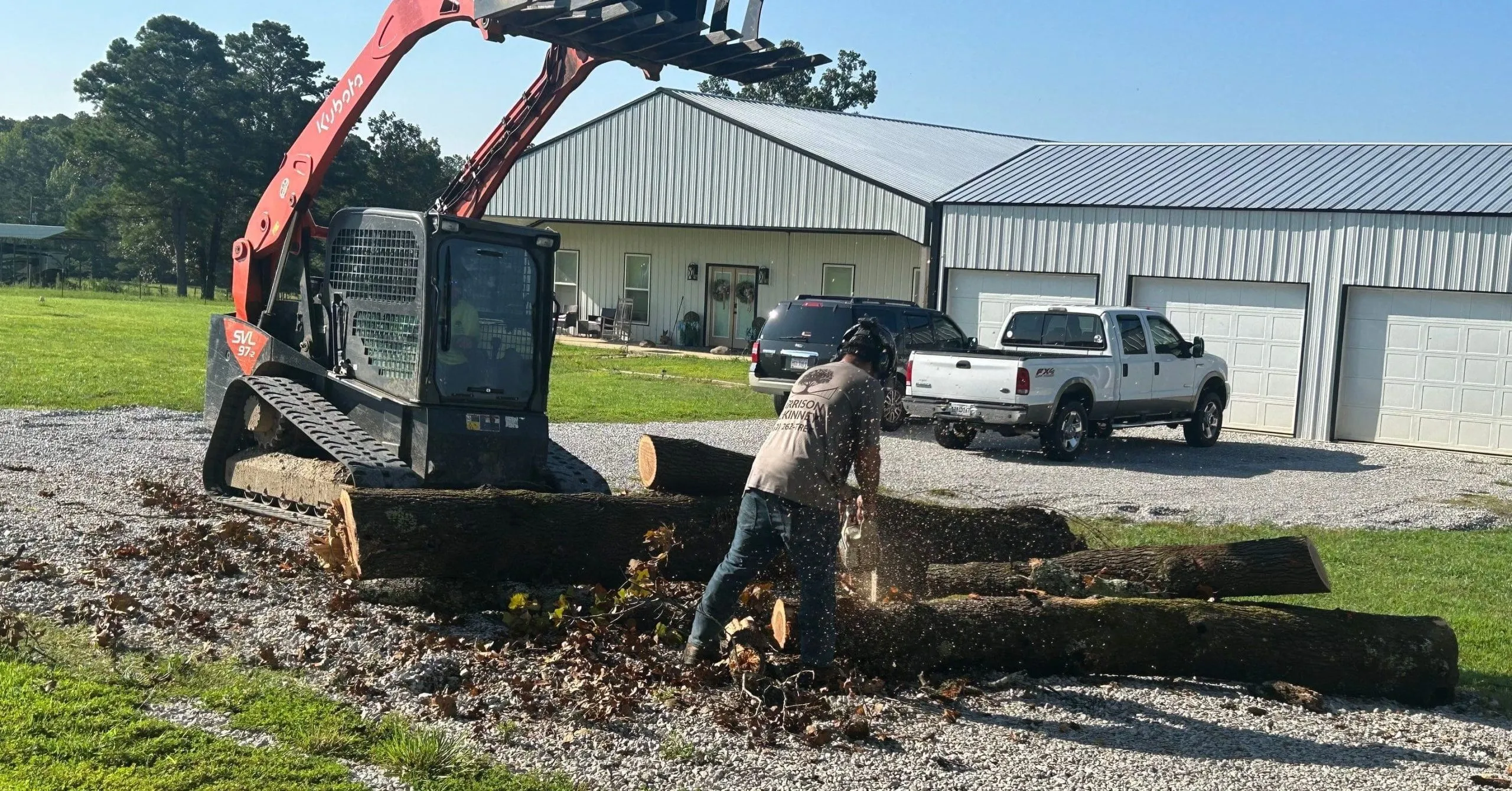 Homeowner raking branches and leaves after storm tree removal cleanup in the yard